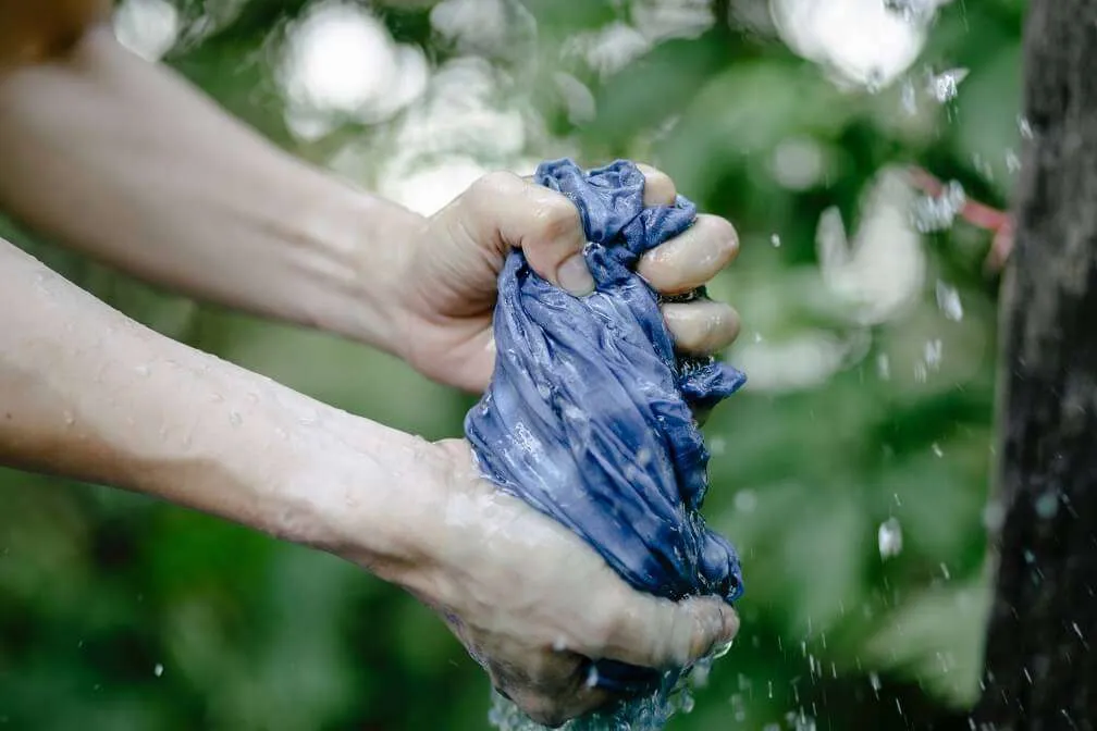 Washing a blue shirt with bare hands