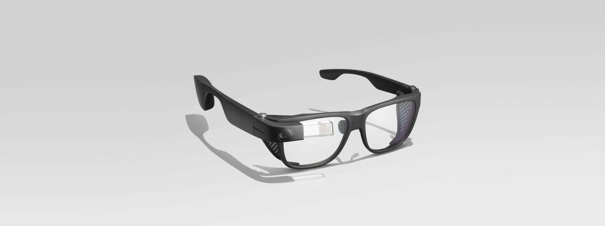 Gafas inteligentes negras con pantalla y cámara incorporadas sobre fondo blanco.